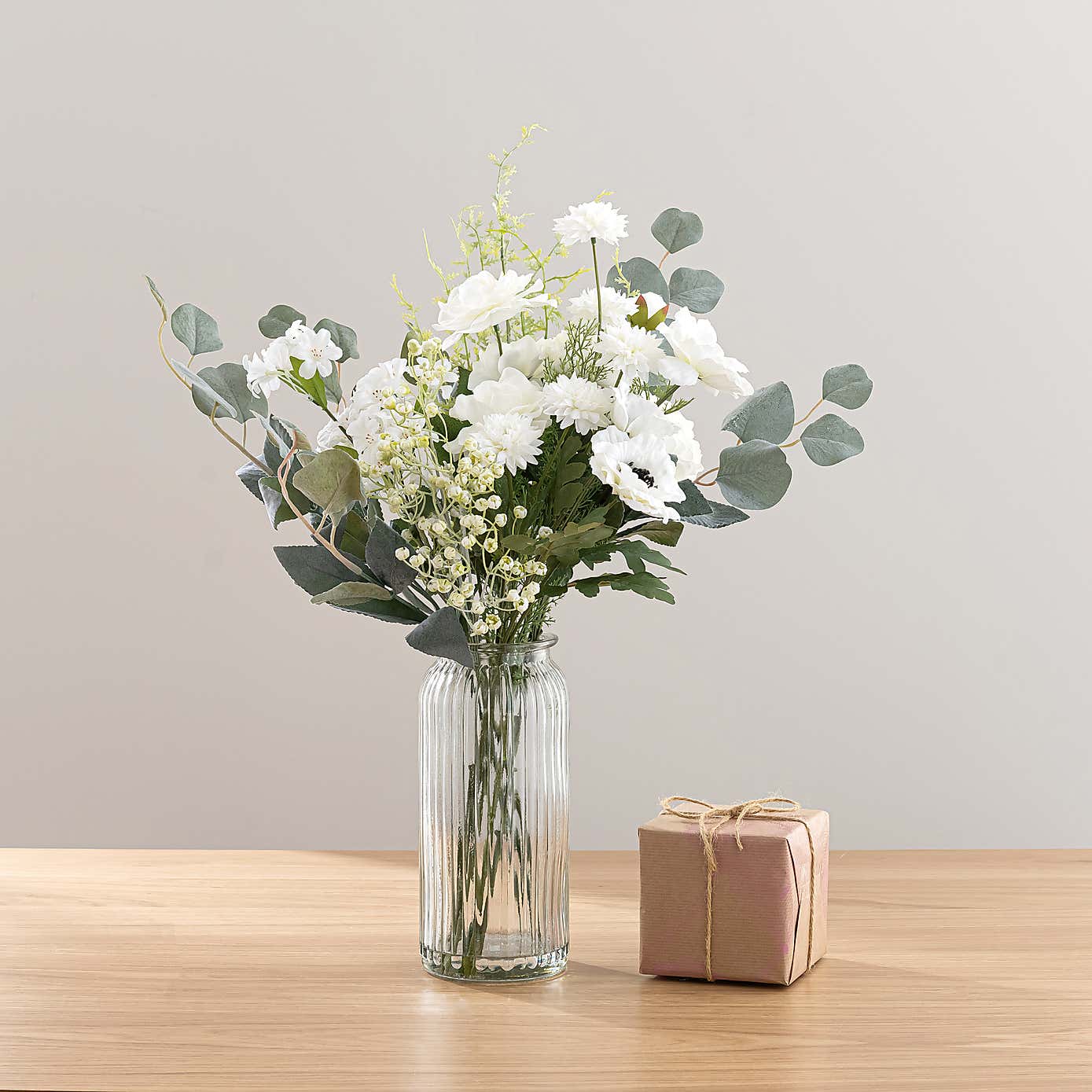 White Rose & Eucalyptus Floral Arrangement in Ribbed Glass Vase with Soft Amber & Pine Candle