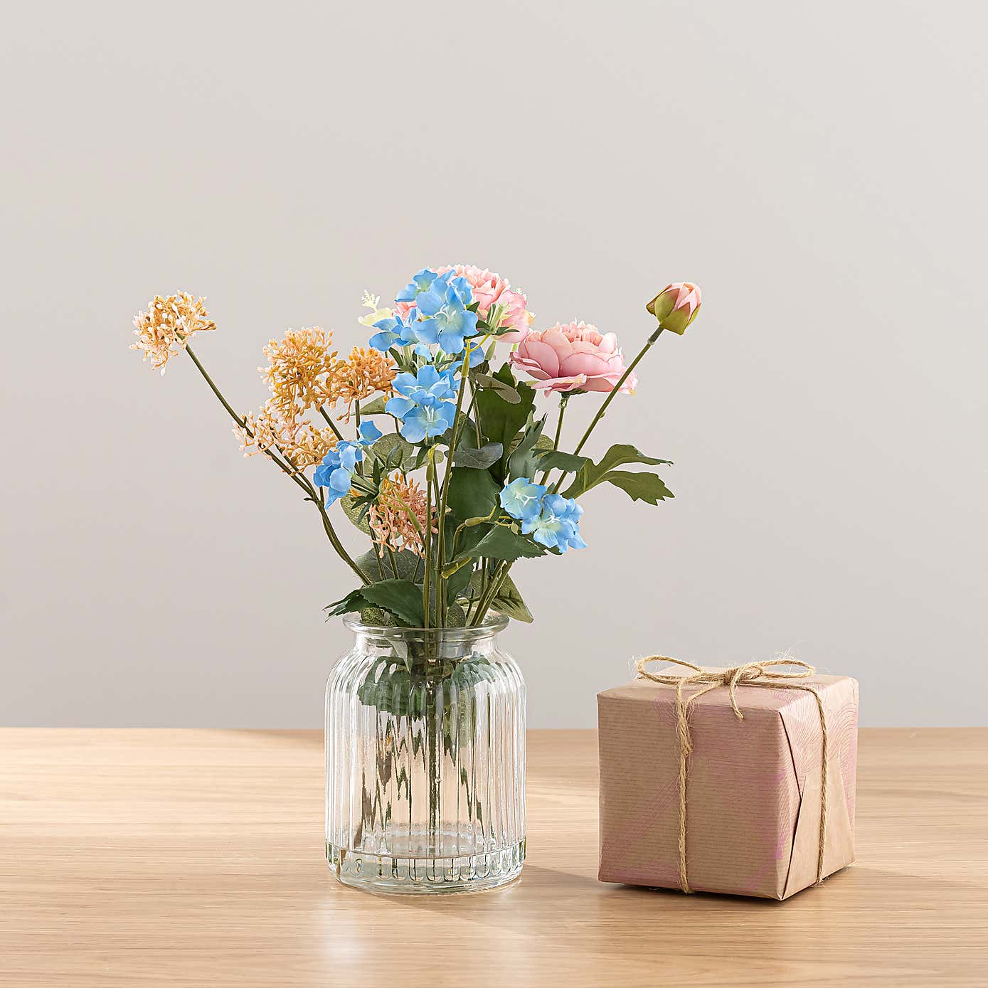 Pink Ranunculus Floral Arrangement in Ribbed Glass Vase with Sweet Jasmine Candle
